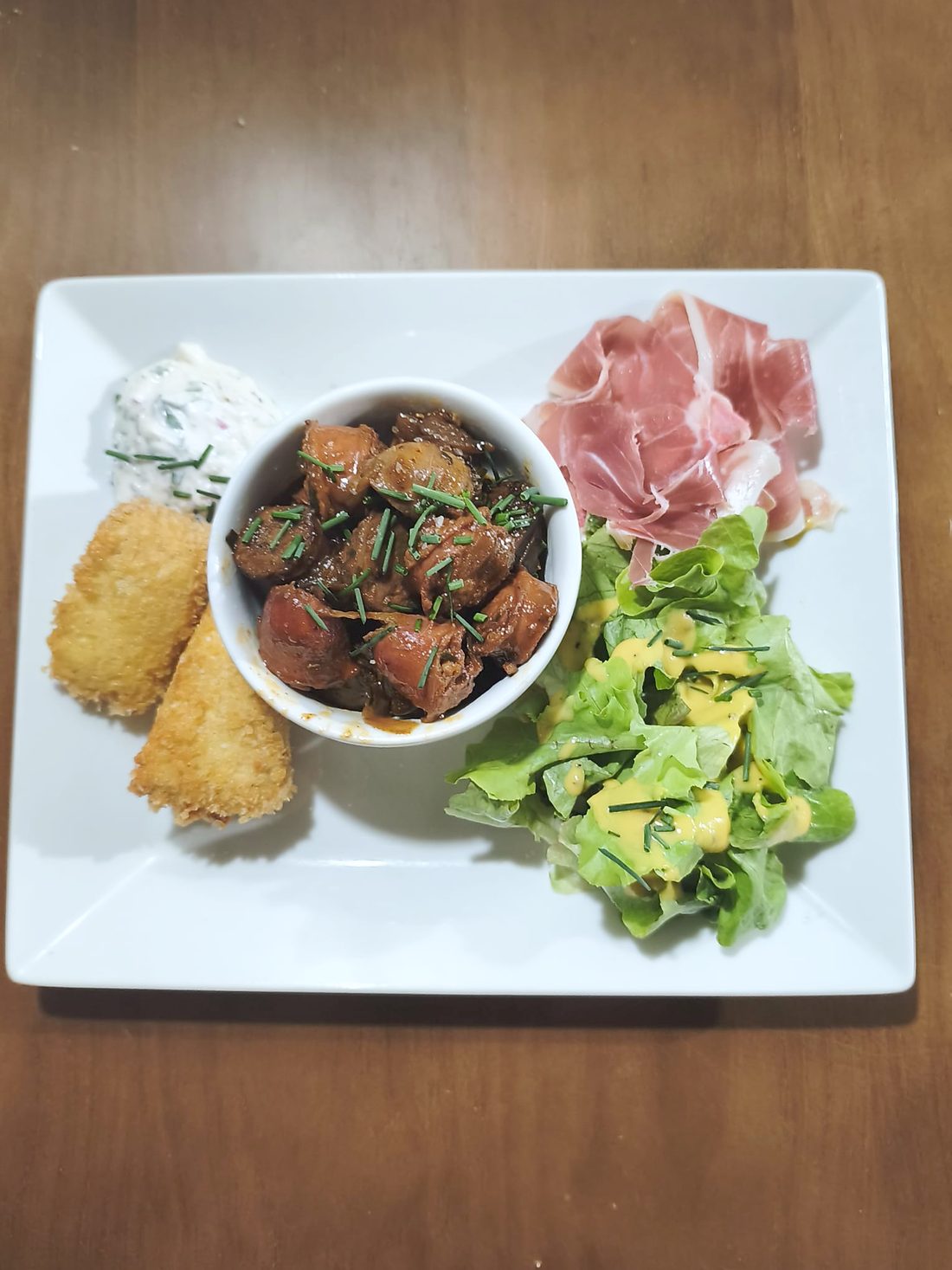 Assiette de tapas du Rendez-vous : patatas bravas en cocotte, jambon cru, camembert pané et salade